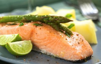 Bildet viser en middagstallerken med et lakestykke, lime, asparges og poteter.