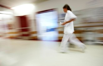 Sykepleier som løper og stresser.