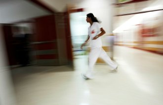 Sykepleier som løper og stresser.