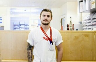 Bildet viser Lasse Johan Thue ved skranken til avdeling for blodsykdommer på Rikshospitalet i Oslo.