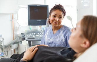 Gravid kvinne undersøkes av en jordmor