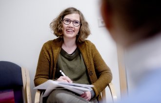 Ruskonsulent Nathalie Idsøe sitter i samtale med pasient ved Stavanger universitetssjukehus.