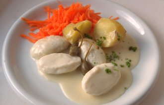 Bildet viser fiskeboller i hvit saus på en tallerken.