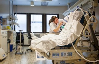 Bildet viser intensivsykepleier Grethe Teigen som steller en pasient i spesialseng.