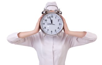 Sykepleier som har en klokke foran ansiktet. Skal illustrere stress Sykepleier som har en klokke foran ansiktet. Skal illustrere stress