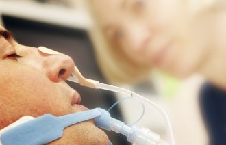 Bildet viser en intubert pasient med ernæringssonde.