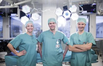 Bildet viser to sykepleiere og en kirurg på operasjonsstuen på Haukeland universitetssjukehus