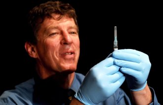 Bildet viser en lege som gjør klart til å administrere en sprøyte.