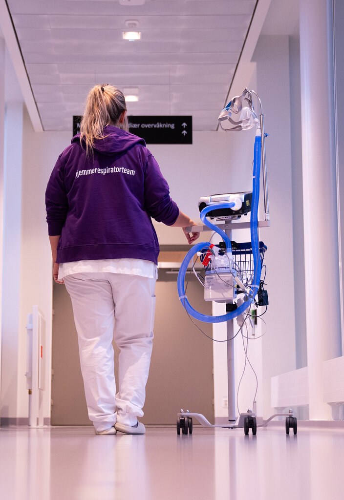 Bilde viser lungesykepleier Ingunn Halvorsen, i korridoren på sykehuset med en pustemaskin