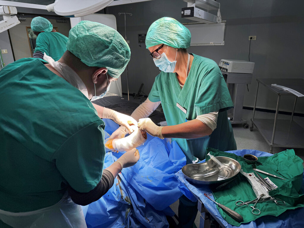 Bildet viser operasjonssykepleier Hilde Vollan og lokal lege som bandasjerer