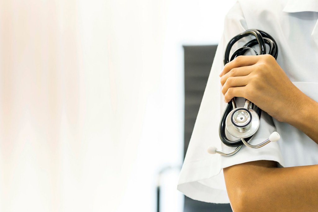 Hånd med stetoskop Beskåret bilde av kvinnelig helsepersonell med stetoskop i hånden.