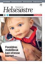En baby sitter på fanget til en forelder og ser på mobilen.