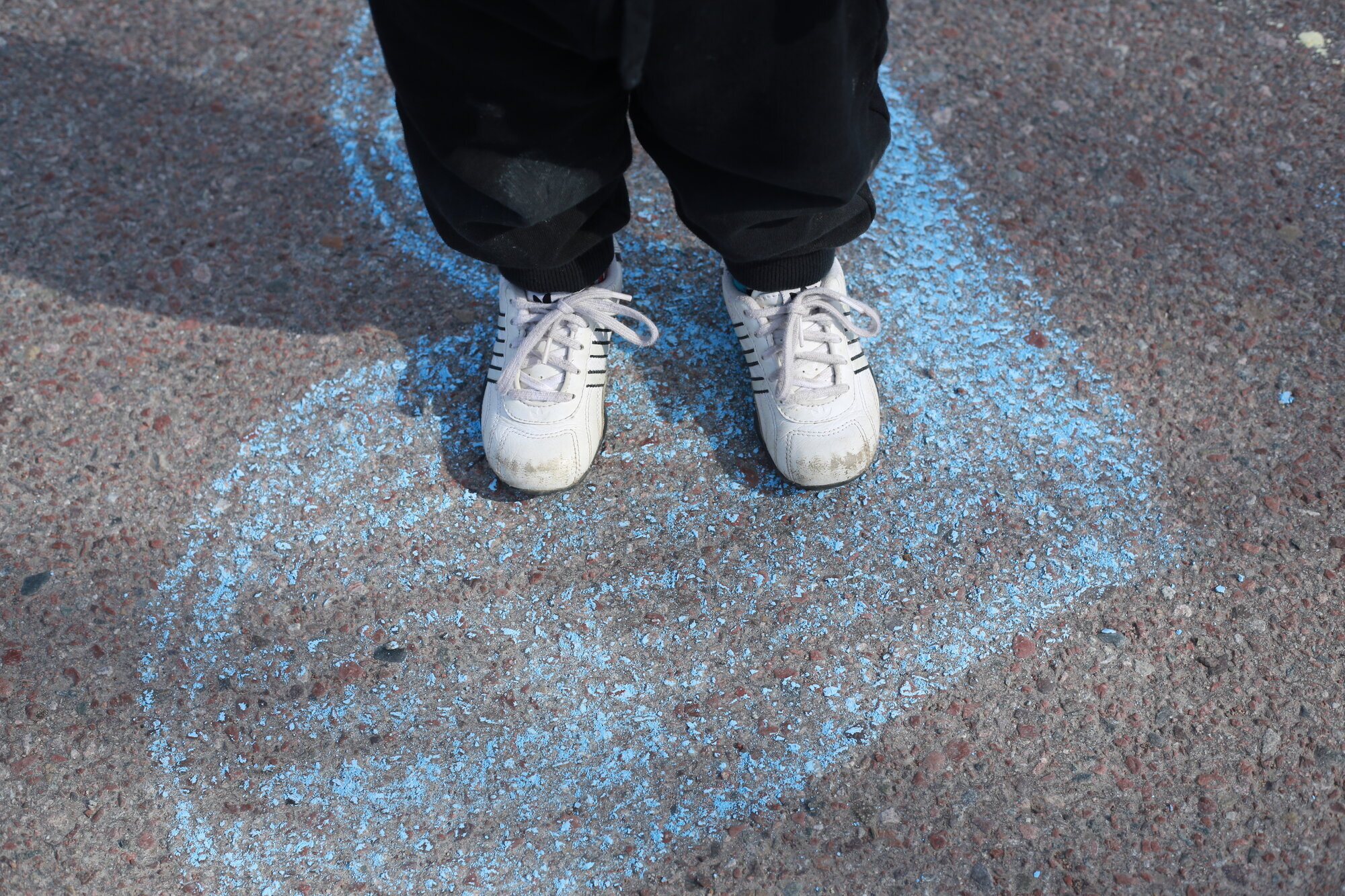 skoleelev og skolehelsjetjeneste Bildet viser et barn som står på et hjertet - tegnet med kritt - i skolegården.