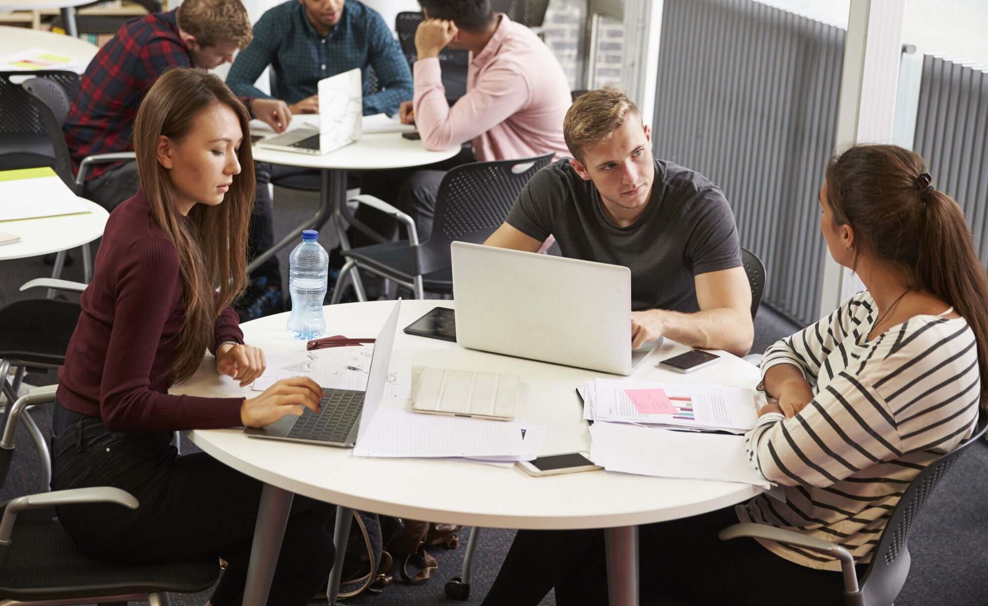 Gruppearbeid Bildet viser studenter som sitter rundt et bord og gjør gruppearbeid.