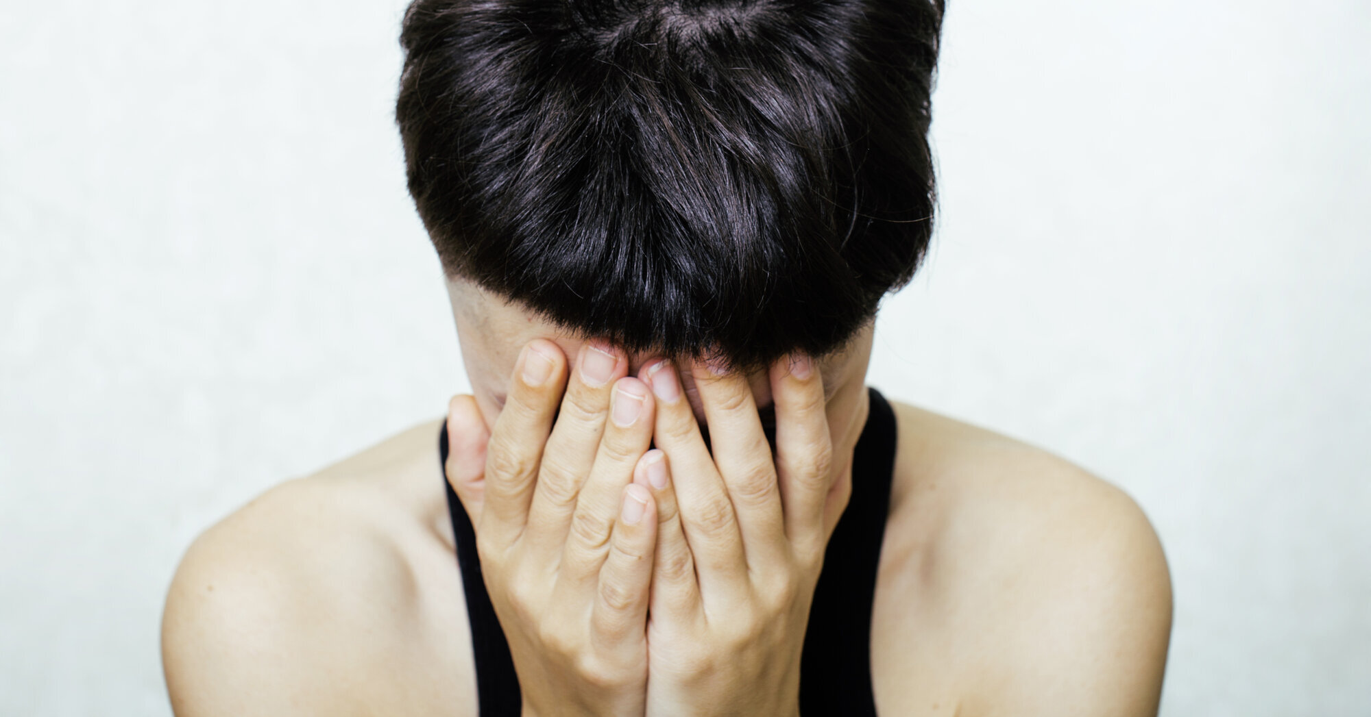 Fortvilet ung dame Bildet viser en ung dame eller jente som fortvilet holder hodet i hendene.