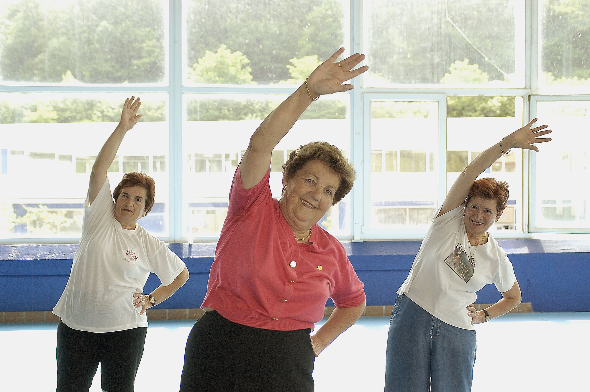 Damer som trimmer Bildet viser tre eldre damer som trimmer i en sal