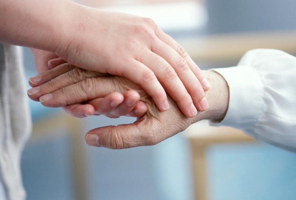Bildet viser to hender som holder hverandre