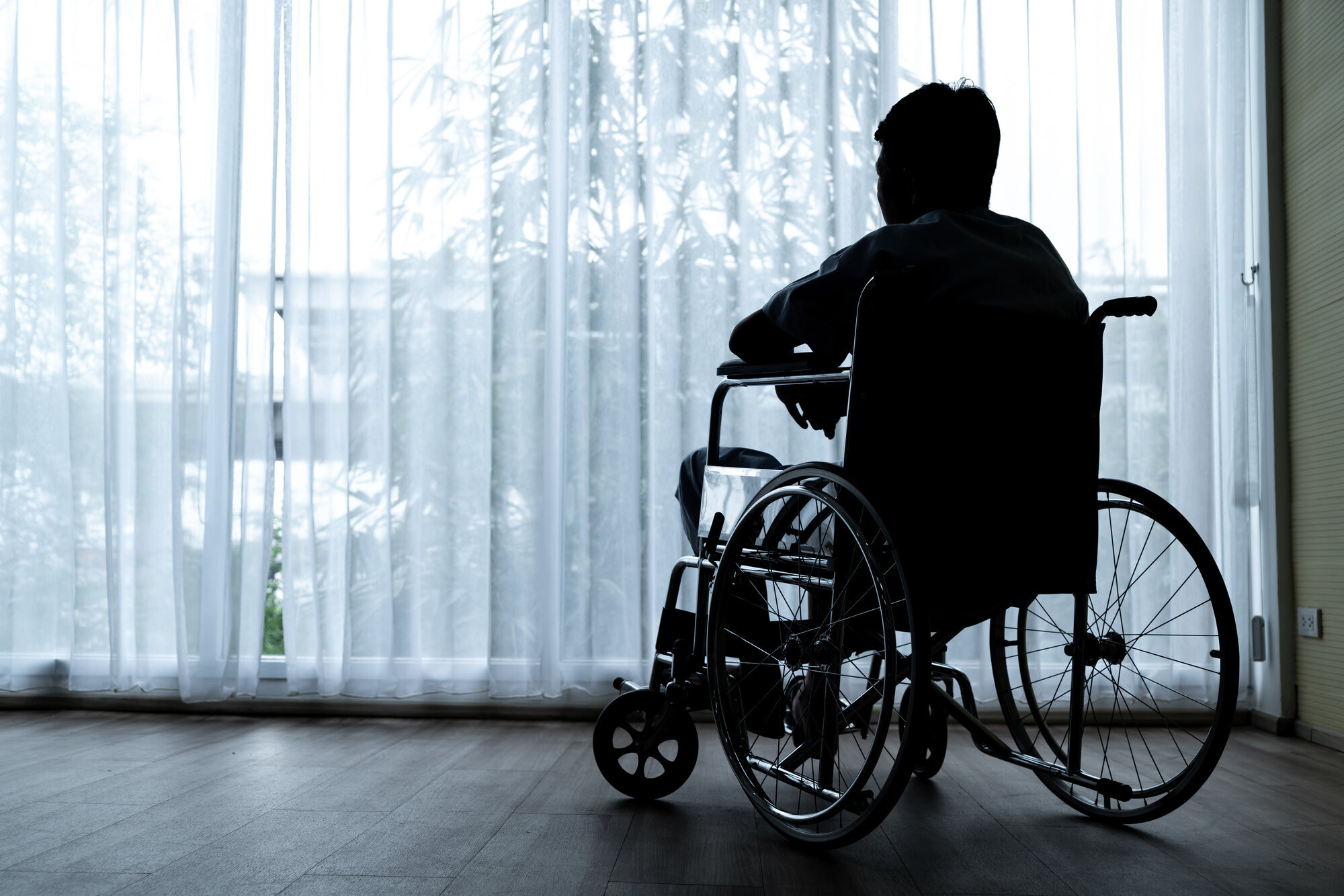 Mann og rullestol Bildet viser en mann som sitter i rullestol.