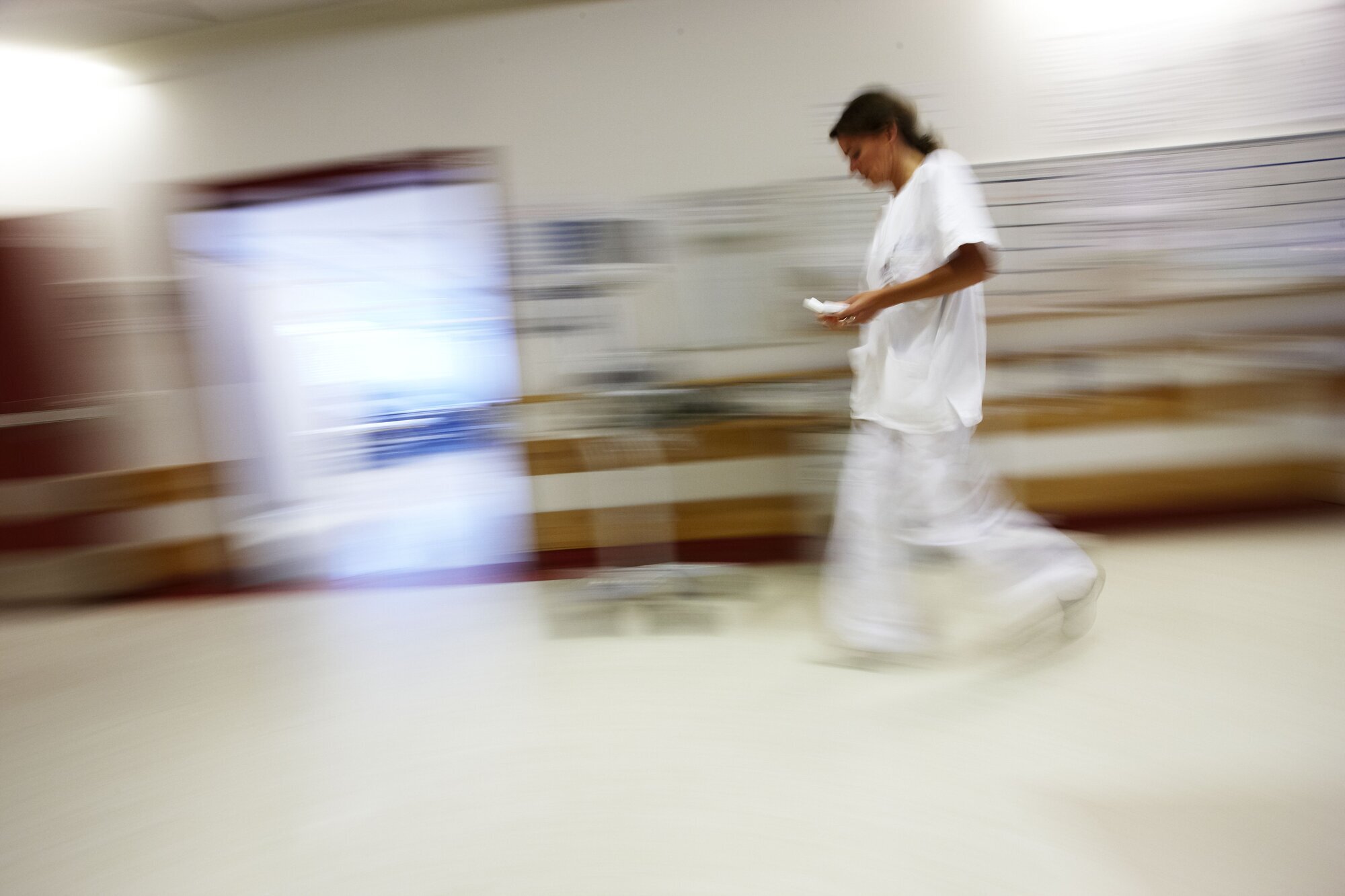 sykepleier, sykehus, stress Bildet viser en sykepleier som går i en korridor.