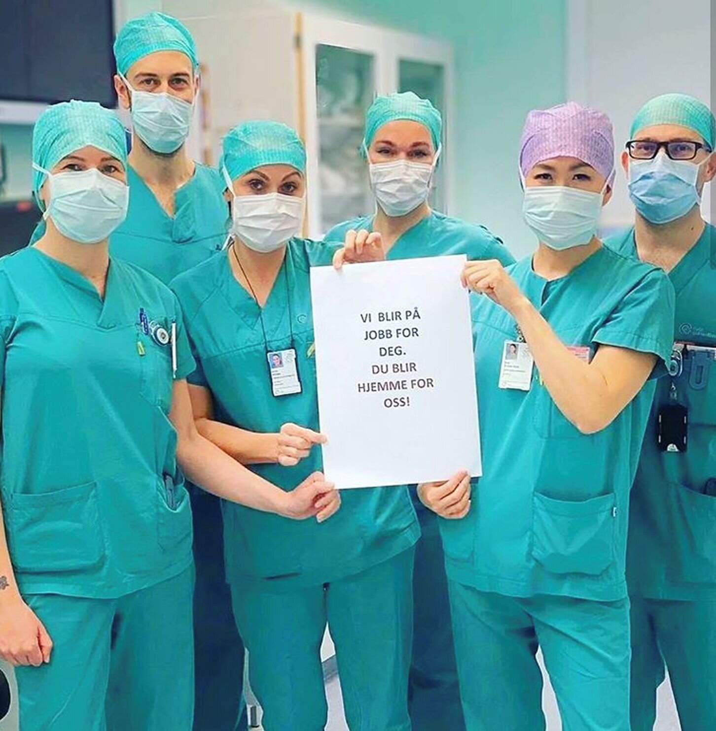 Operasjonssykepleierne Bildet viser operasjonssykepleiere som holder opp et ark.