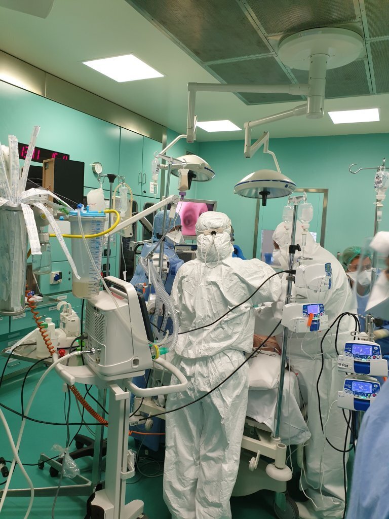 Medisinsk innsatsteam Bildet viser helsepersonell i smittevernutstyr som utfører en undersøkelse på en pasient.