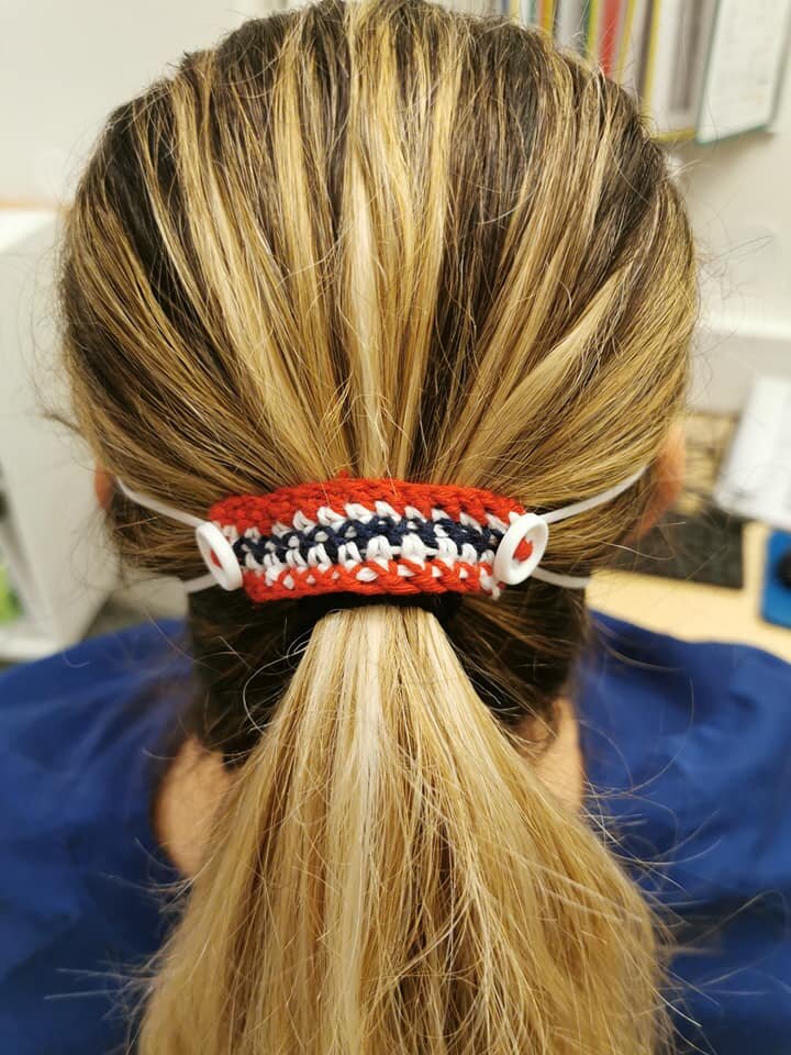 avlaste ørene, munnbind Bildet viser en slags hårspenne, heklet av bomullsgarn, med to knapper på.