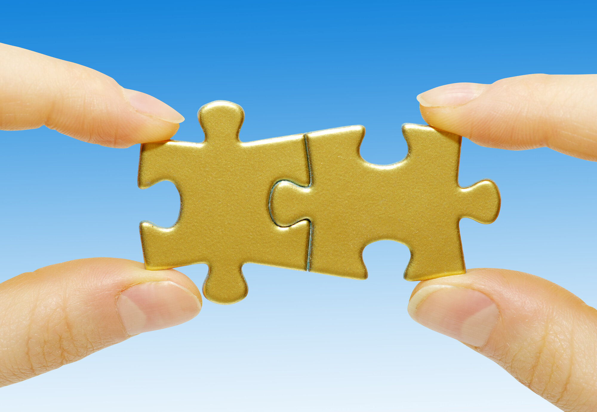 Tettere samarbeid gir bedre resultater. Bildet viser to hender som holder hver sin puslespillbit som er puslet sammen.