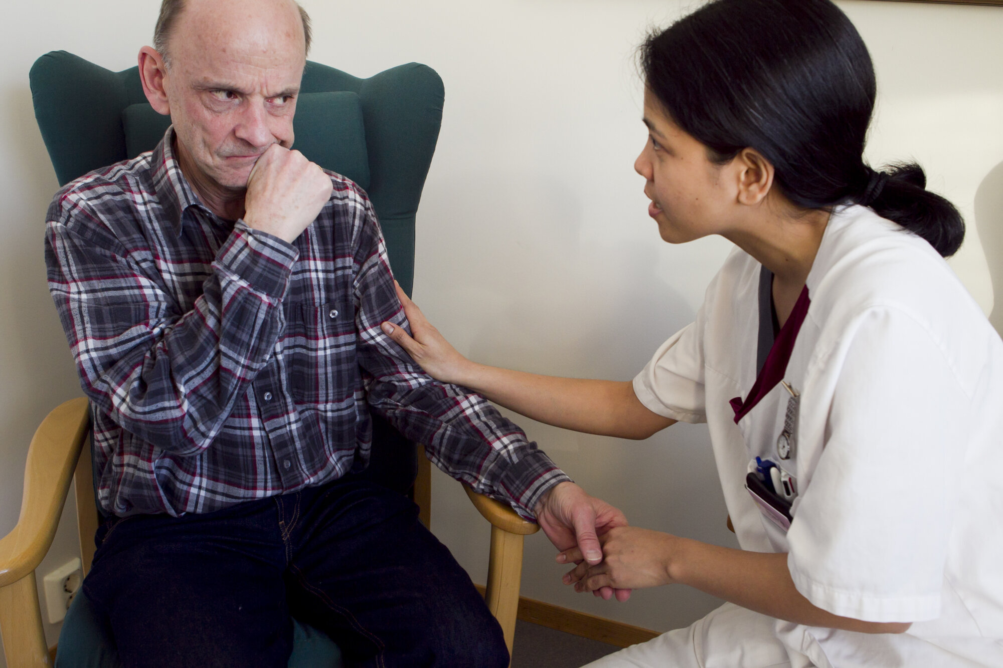 Pleier holder hånden til opprørt, eldre mann Pleier holder hånden til opprørt, eldre mann