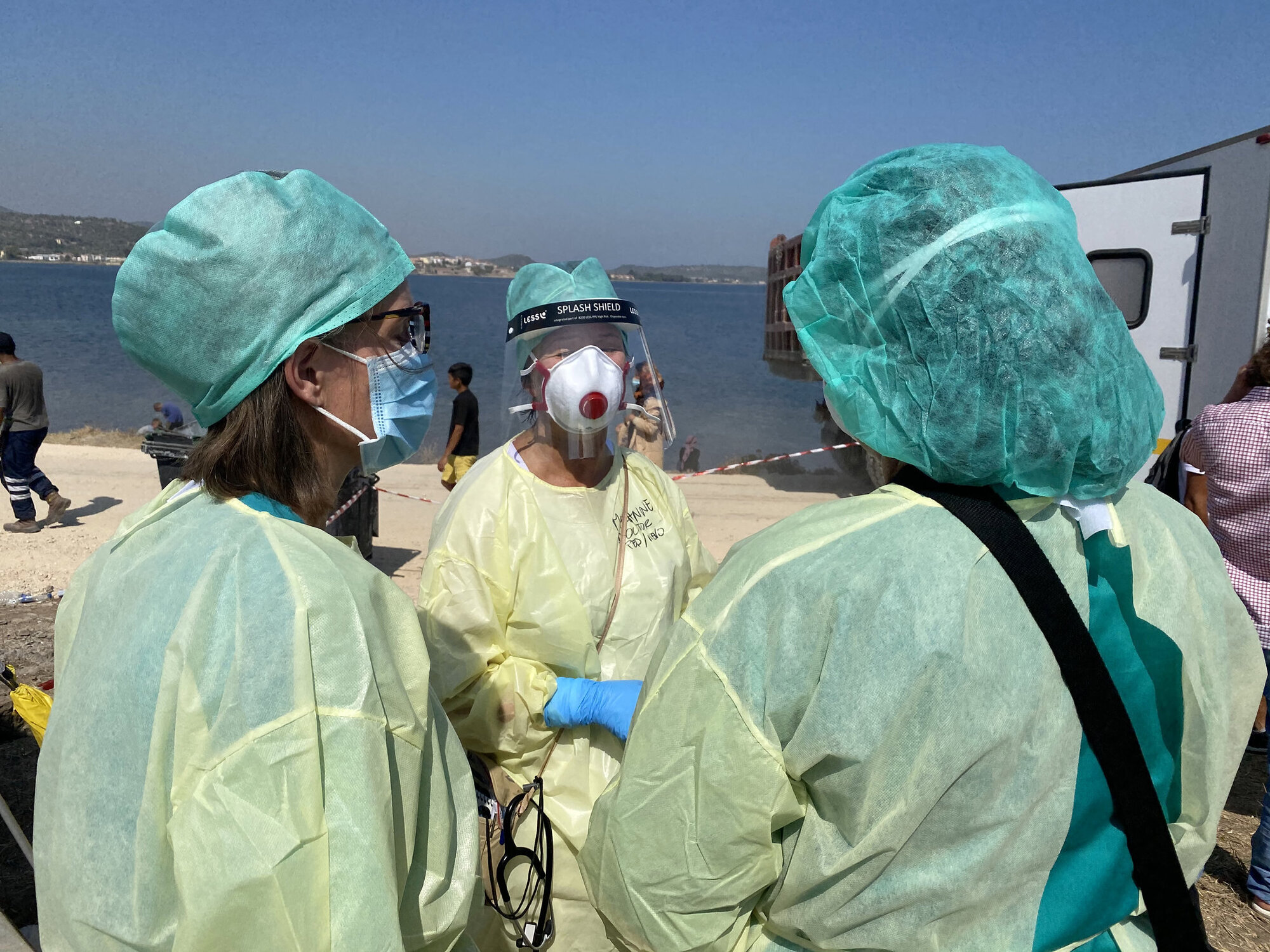 Medisinsk innsatsteam Bildet viser helsepersonell i smittevernutstyr på en strand.
