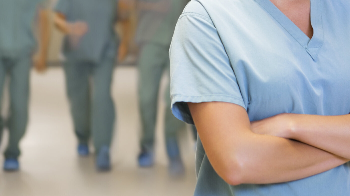 Sykepleier Bildet viser en sykepleier i forgrunnen med armene i kors