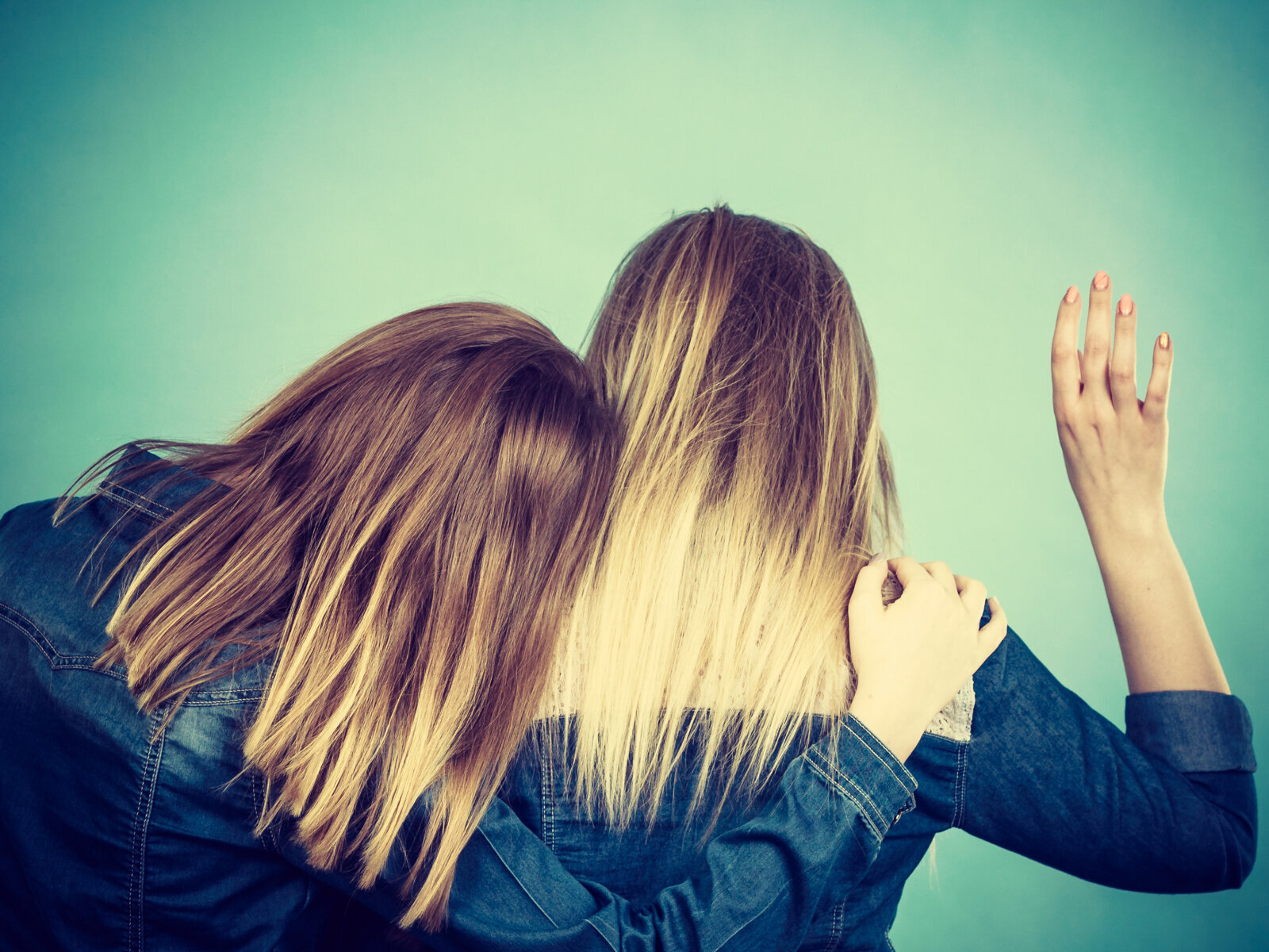 Klemmer, kvinner Bildet viser to kvinner bakfra som klemmer.