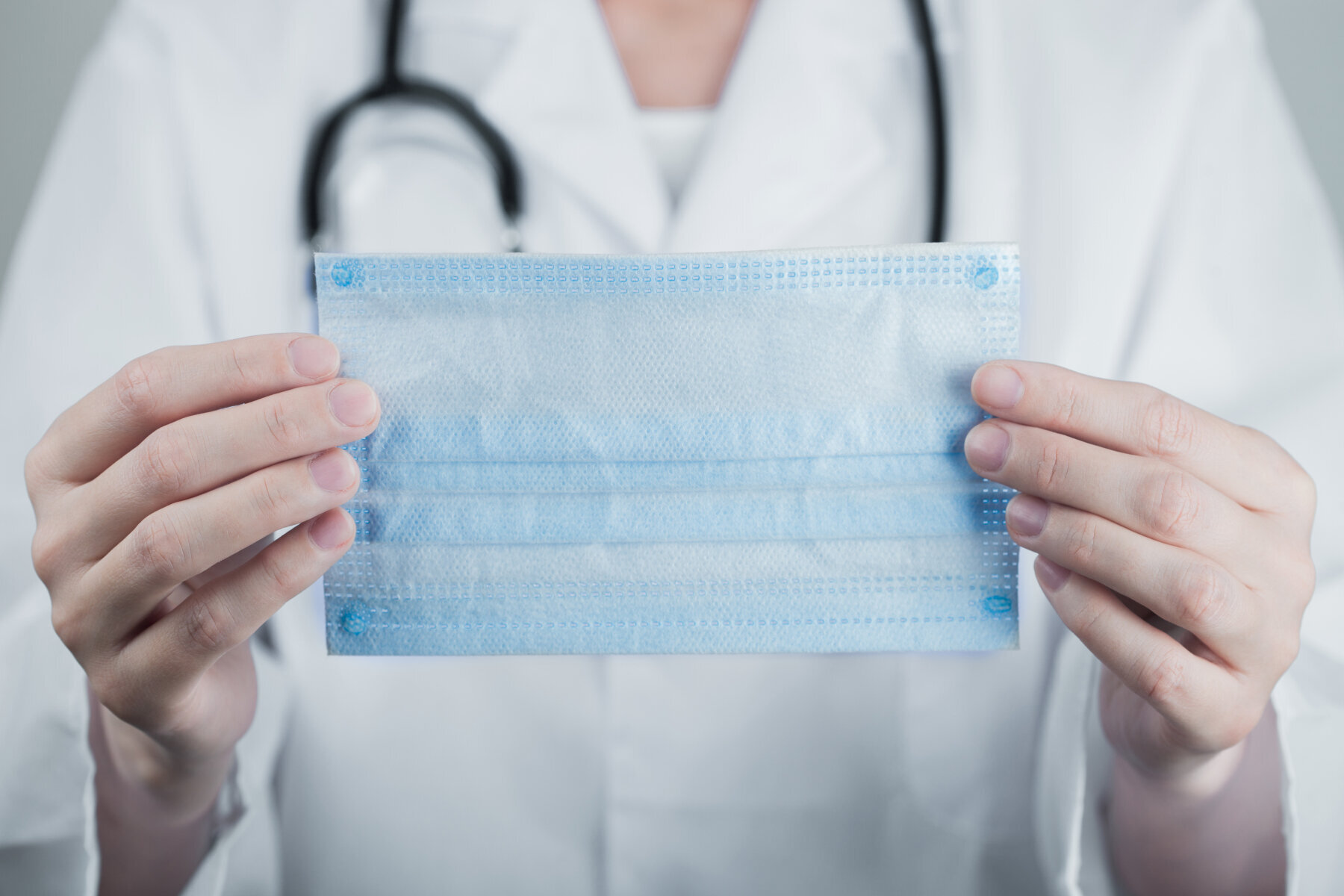 Munnbind Bildet viser et menneske som holder frem et blått munnbind.
