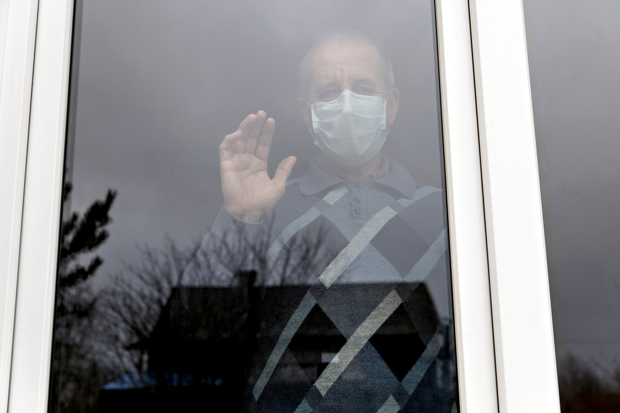 Koronakarantene Eldre mann med munnbind bak vindu