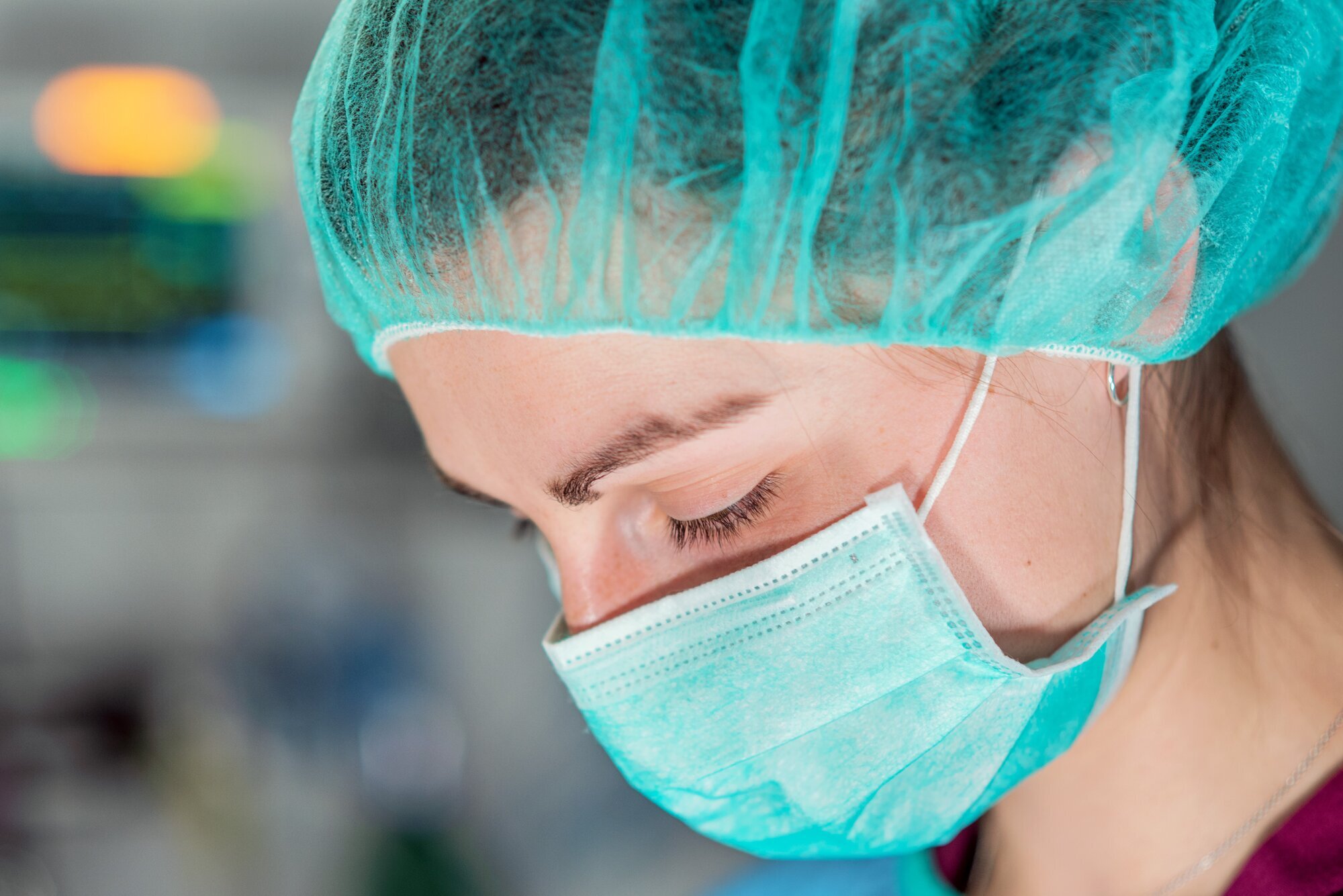 Bildet viser nærbildet av en kvinne med munnbind og hårnett.
