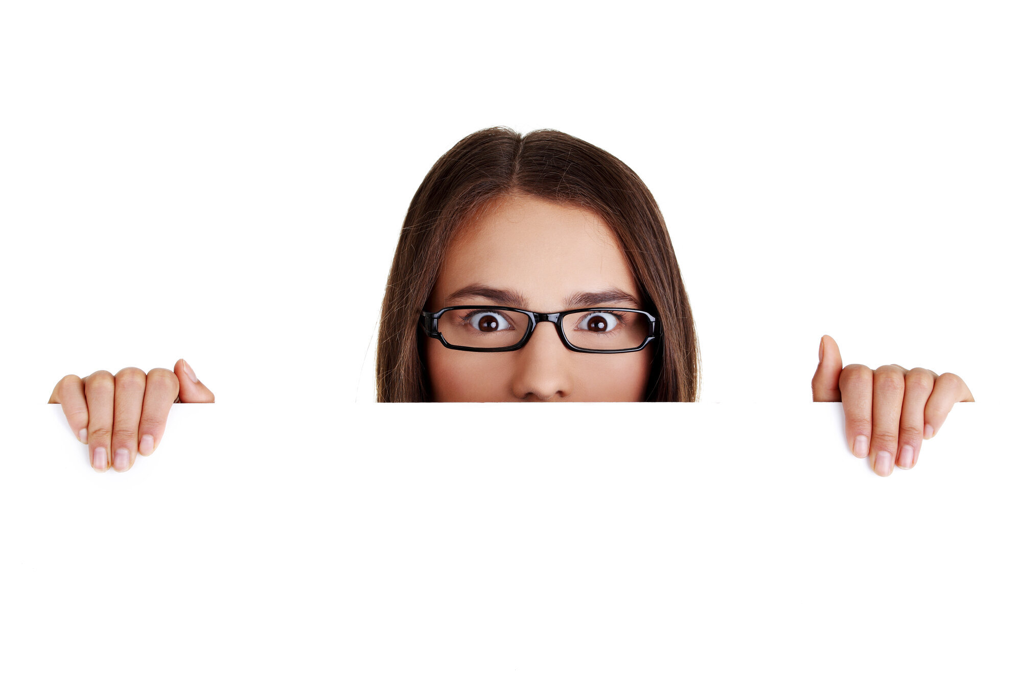 Overrasket kvinne Bildet viser en kvinne med oppsperrede øyne som titter over en kant