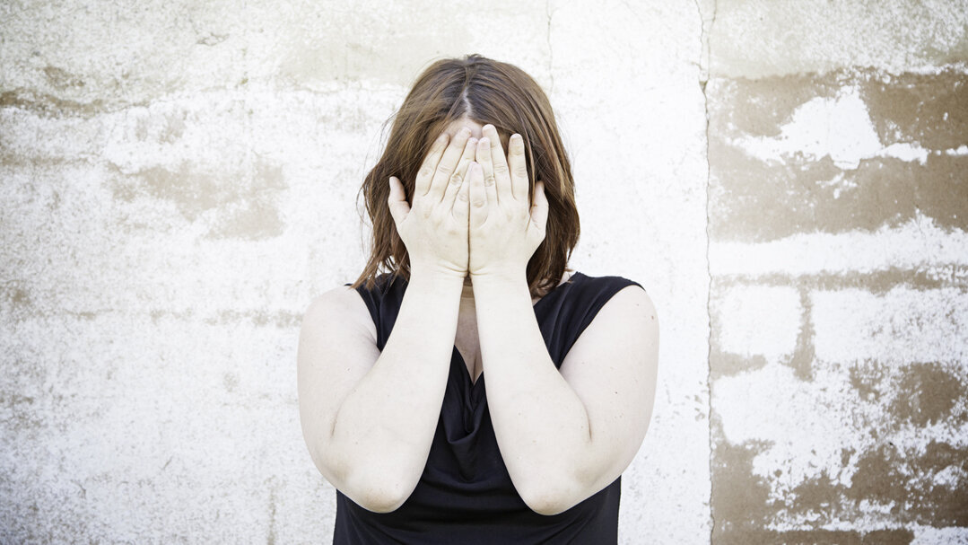 Kvinne som dekker ansiktet med hendene Bildet viser en kvinne som dekker ansiktet med hendene