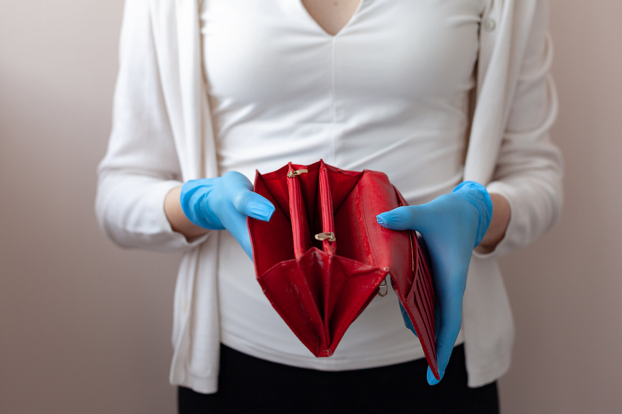 Tom lommebok Bildet viser et utsnitt av en kvinne som viser frem en tom lommebok