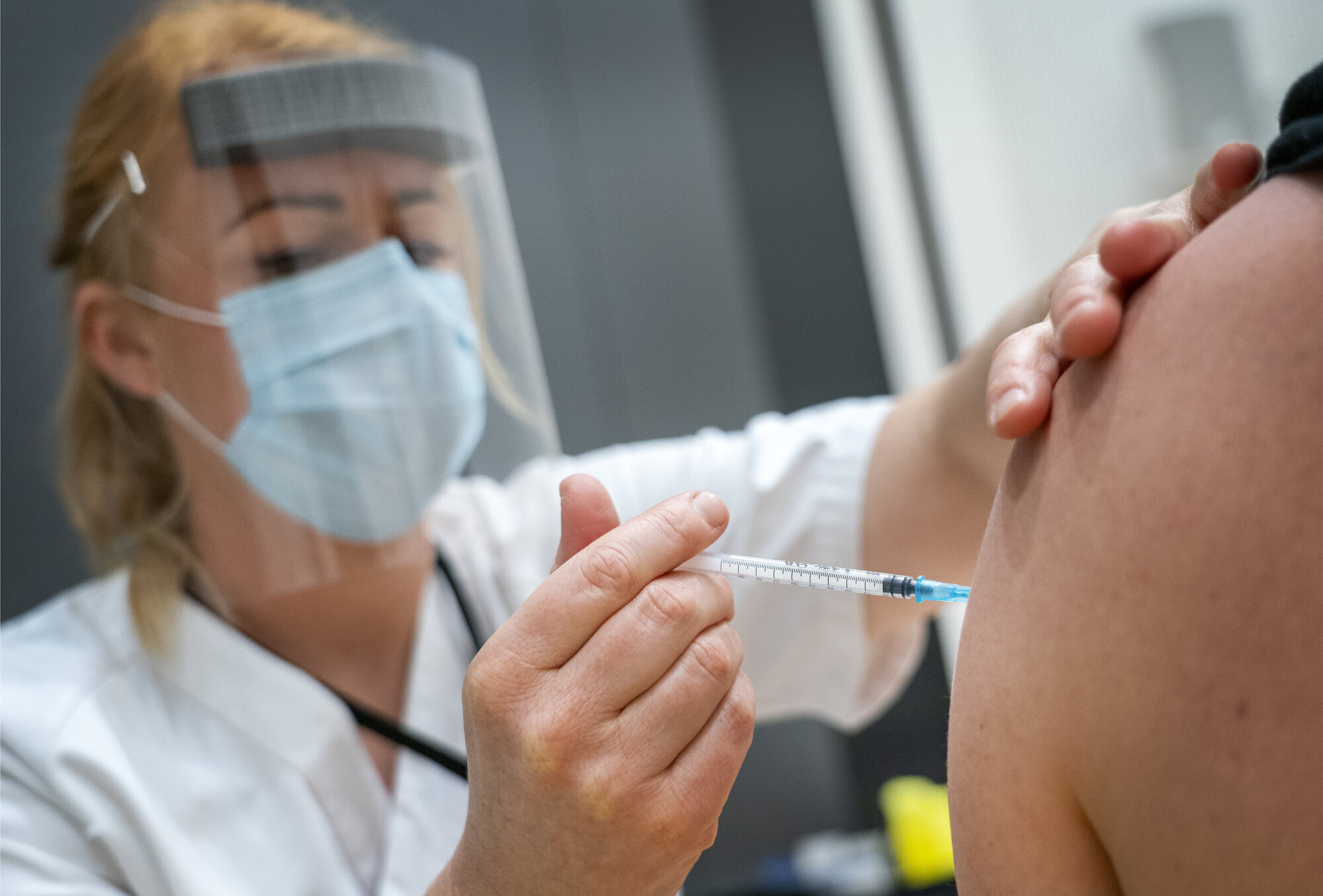 Vaksinesprøyte settes i arm av helsepersonell. Vaksinesprøyte settes i arm av helsepersonell.