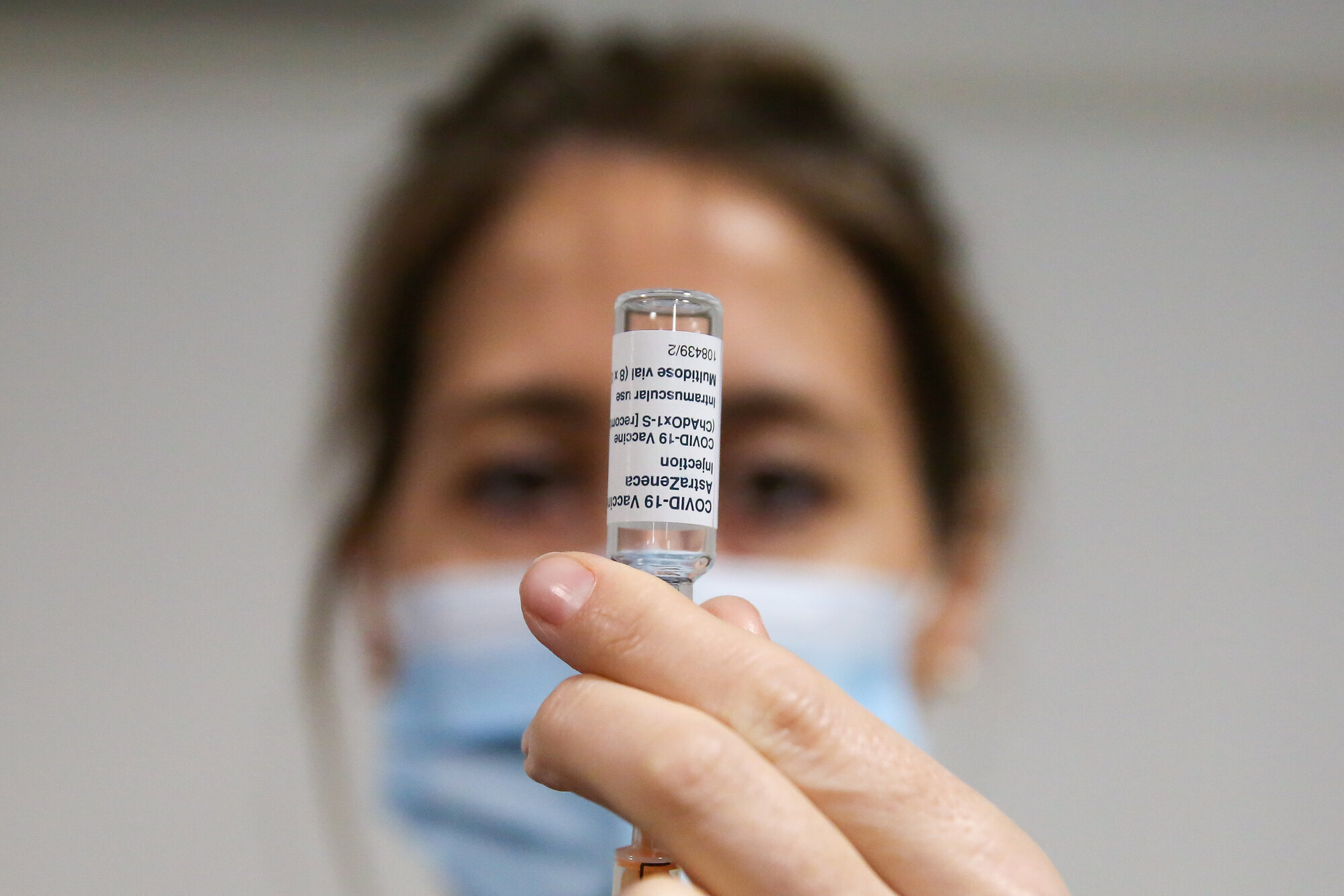 Bildet viser en helsearbeider som trekker opp en koronavaksine.