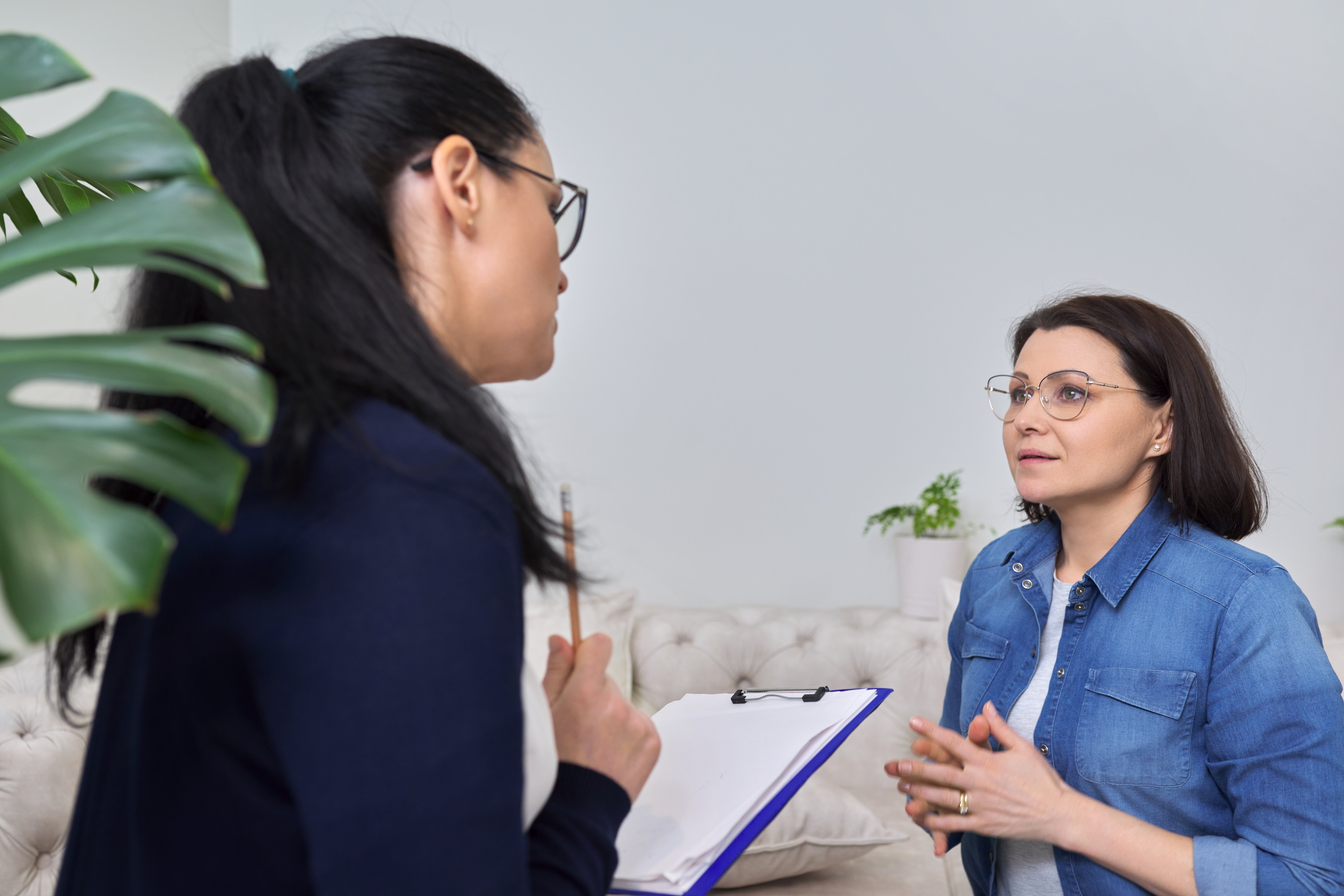 Diabetessykepleier går gjennom skjema med pasient En sykepleier går gjennom et skjema sammen med en pasient på et vente værelse