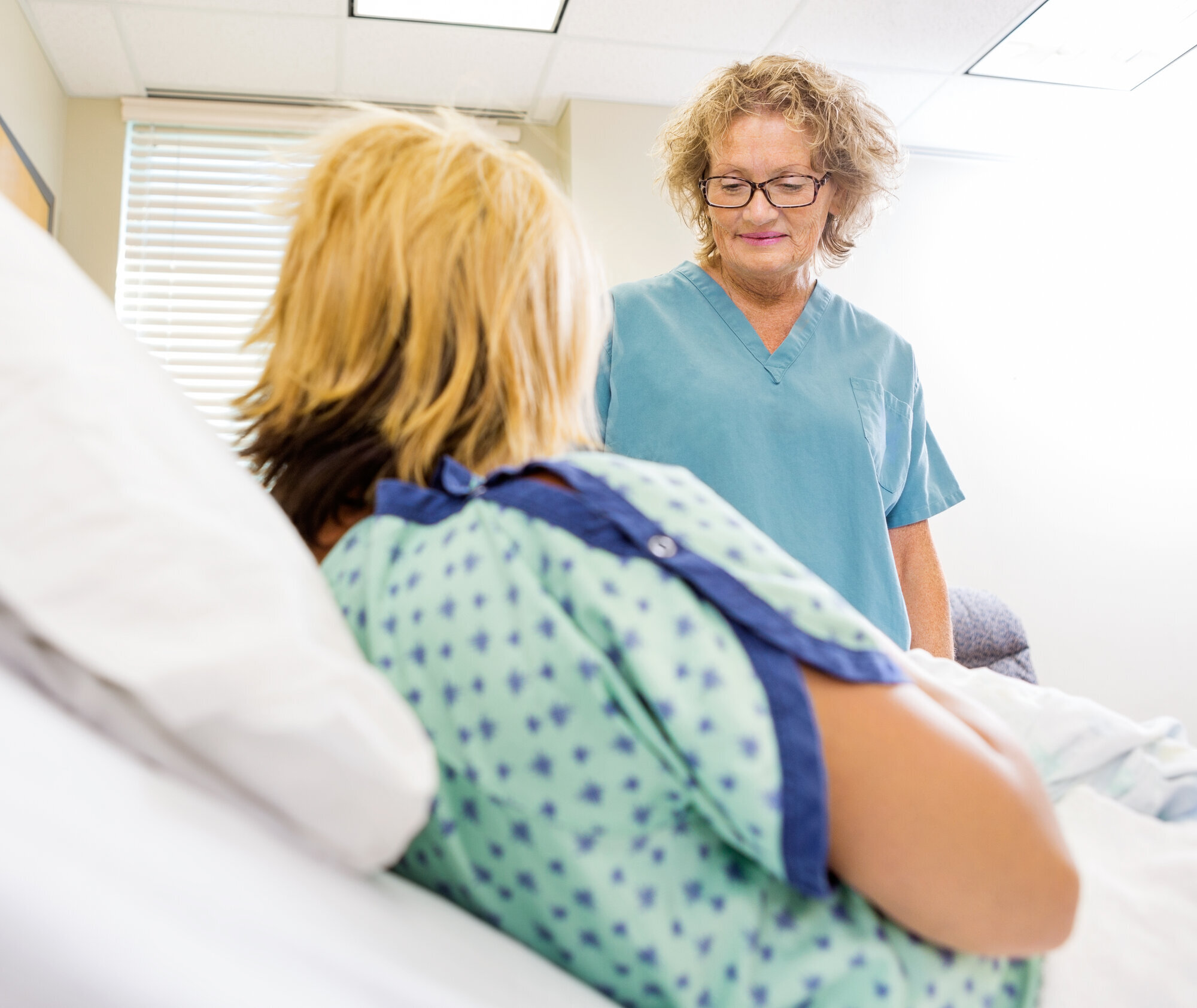 Sykepleier ser på nyfødt og moren Sykepleier ser på nyfødt og moren