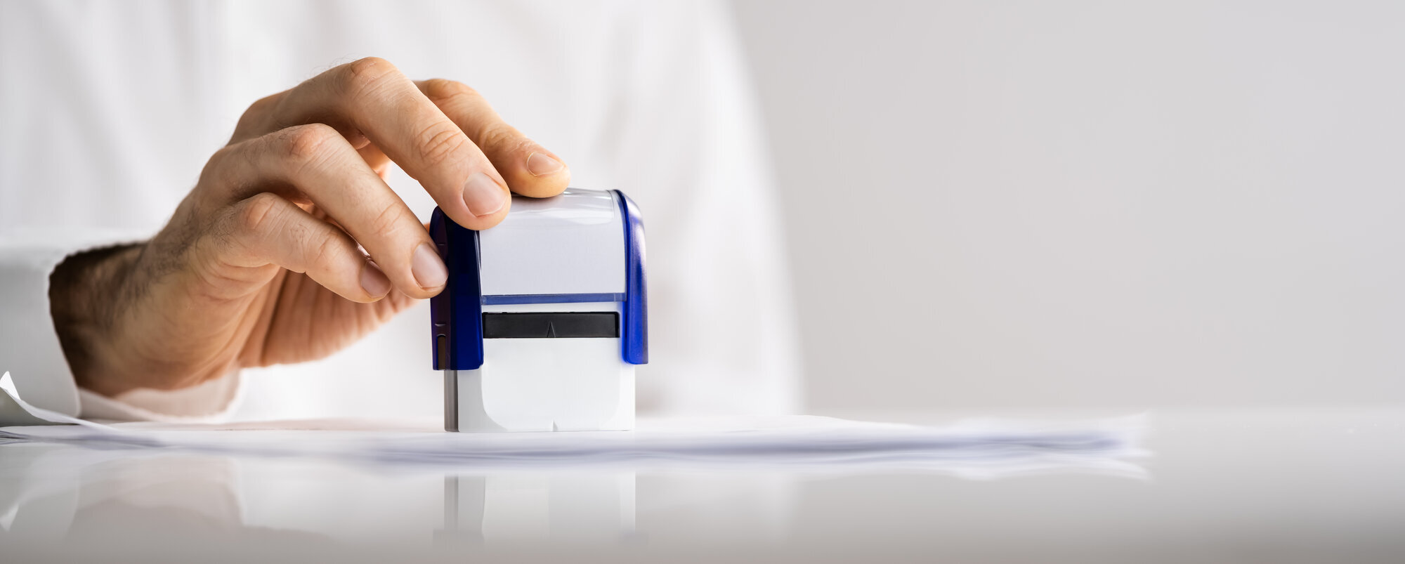 Spesialgodkjenning Bildet viser en mann som er i ferd med å stemple et papir