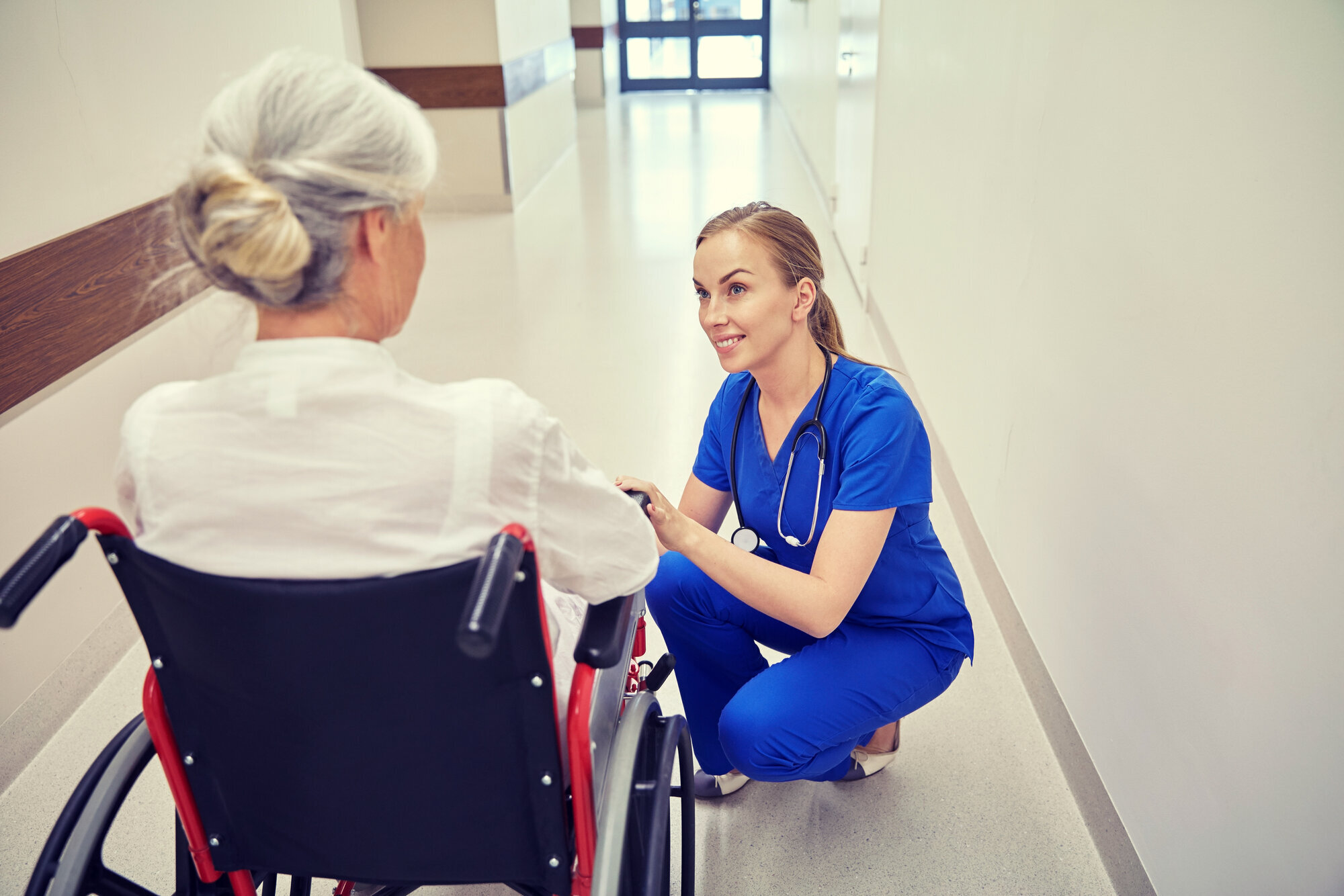En sykepleier har en samtale med en pasient En sykepleier har en samtale med en pasient