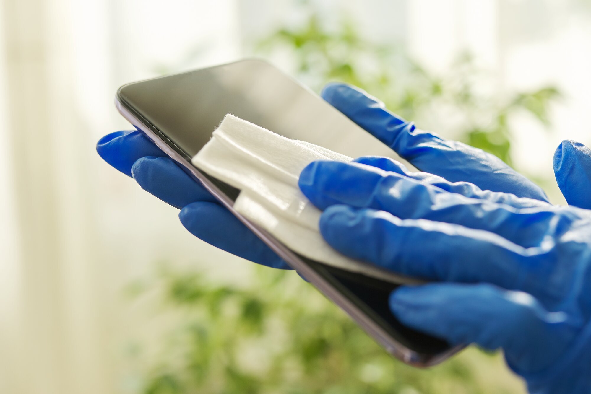 Smittevern Bildet viser en mobiltelefon som blir desinfisert med en klut