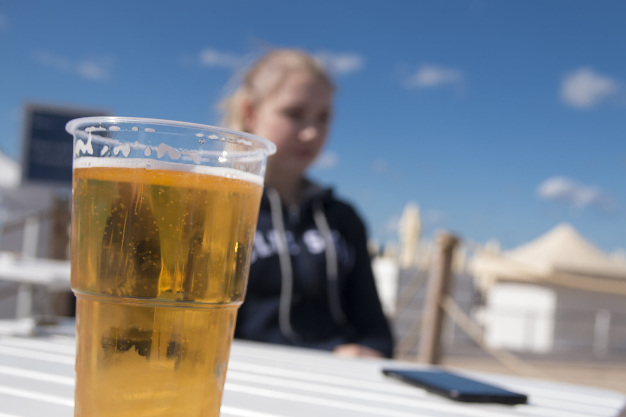 Øl og alkohol Bildet viser en utepils med en ungdom i bakgrunnen