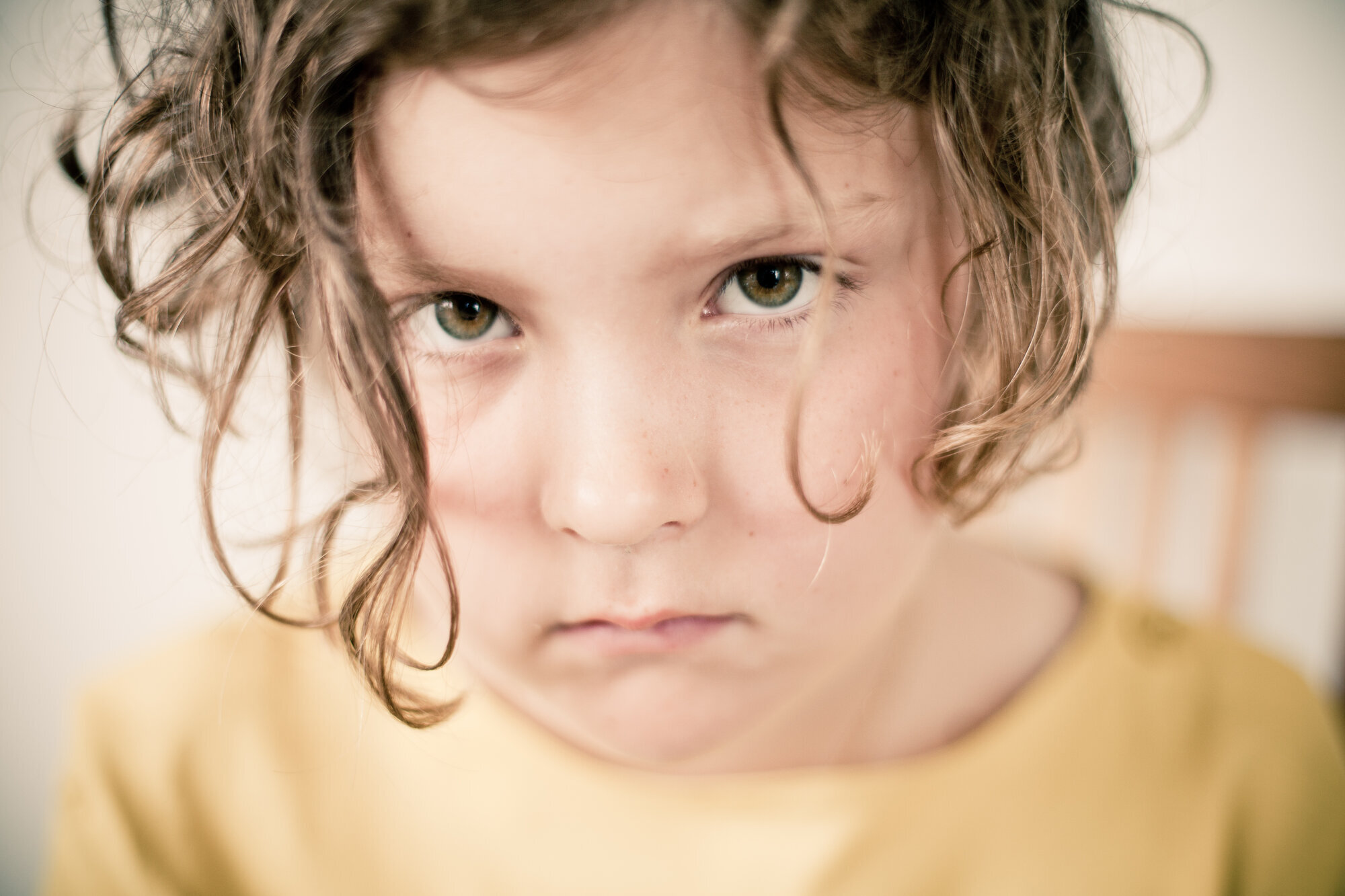 Bildet viser et trist barn som ser inn i kamera