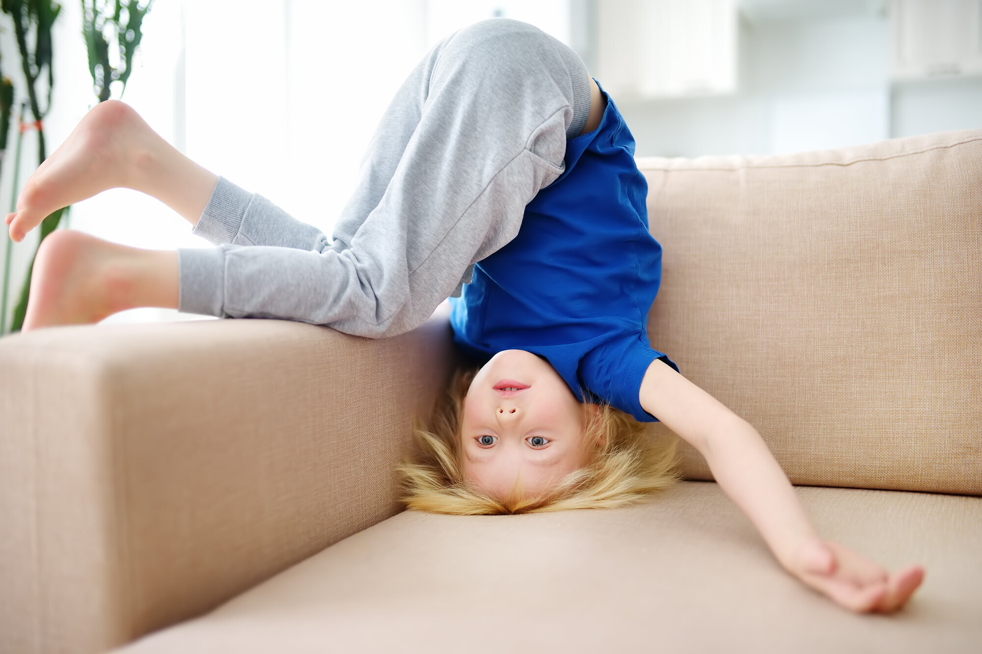 Et barn står på hodet i sofaen Et barn står på hodet i sofaen