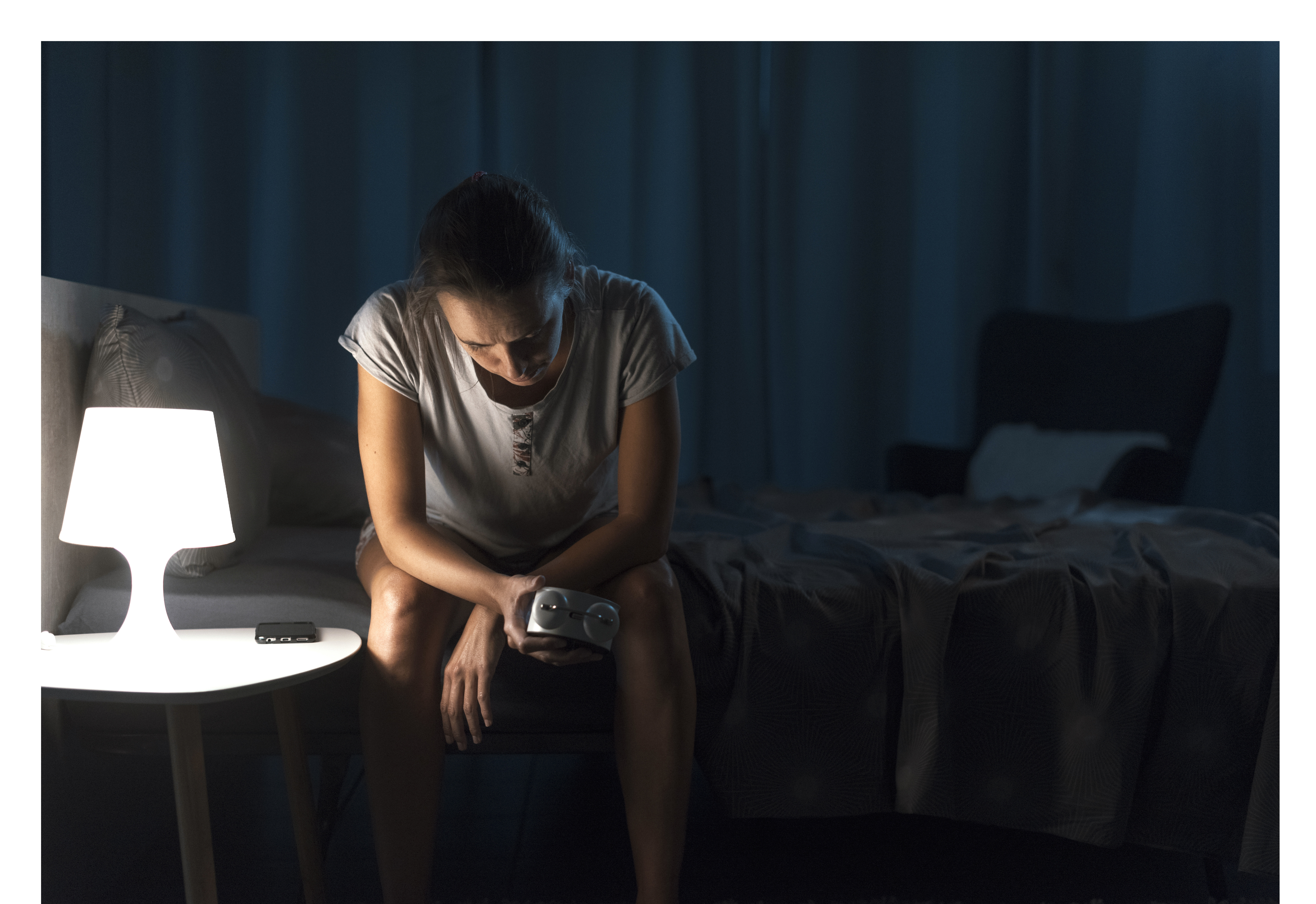 Søvnplager Bildet viser en kvinne som sitter på sengekanten og ikke får sove