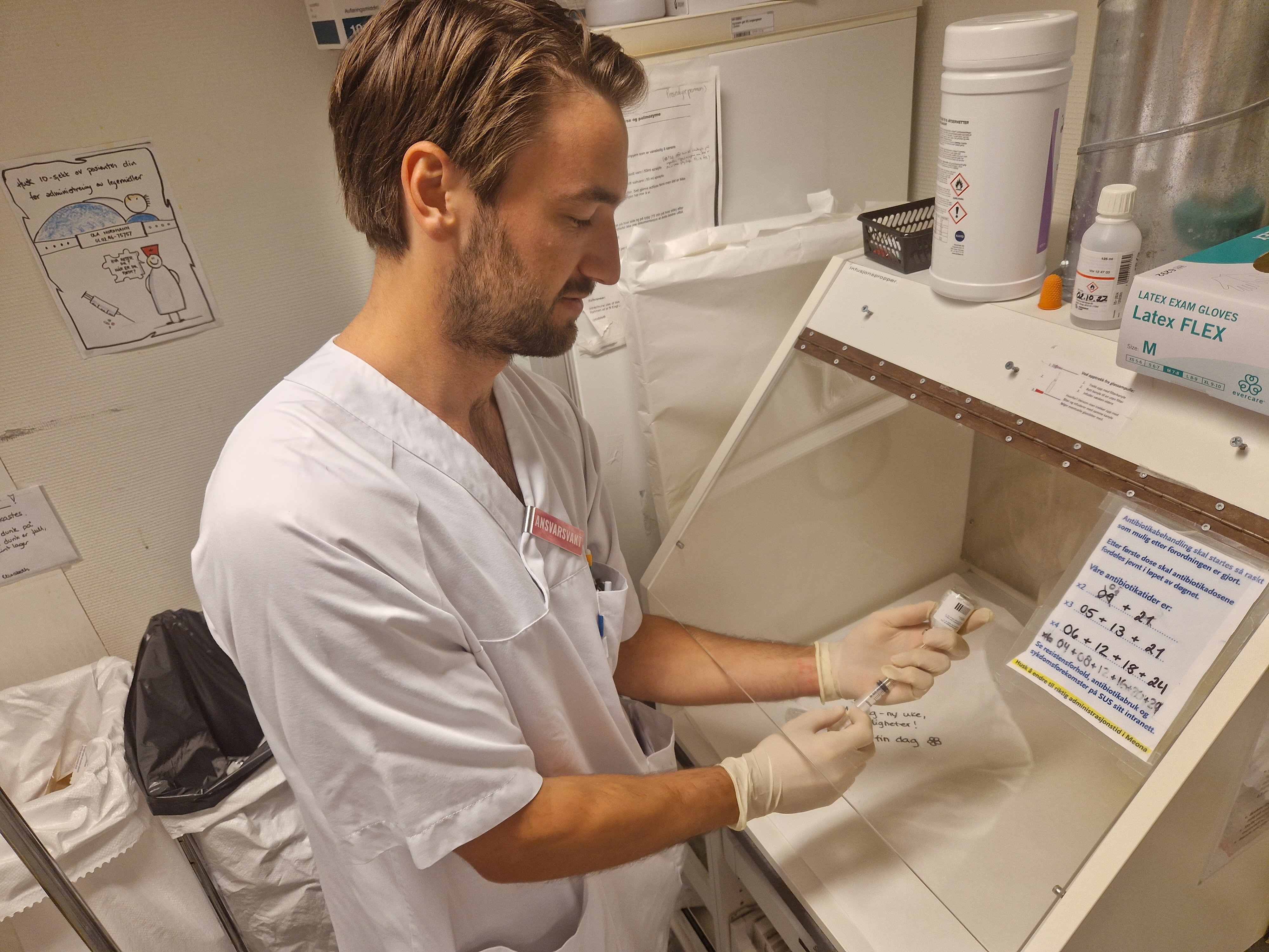 Sykepleier klargjør en sprøyte med antibiotika En mannlig sykepleier klargjør en sprøyte med antibiotika.