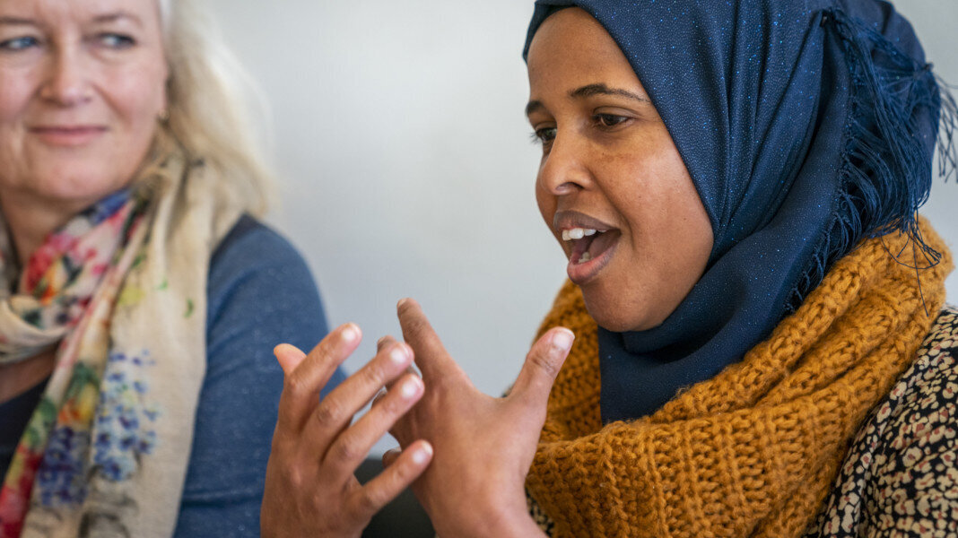 Lærer og student En ung student gestikulerer og prater mens en lærer lytter.